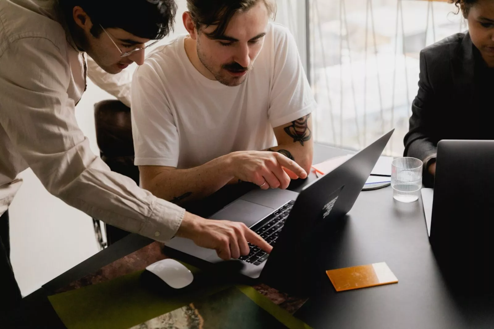 Picture of people collaborating around one laptop